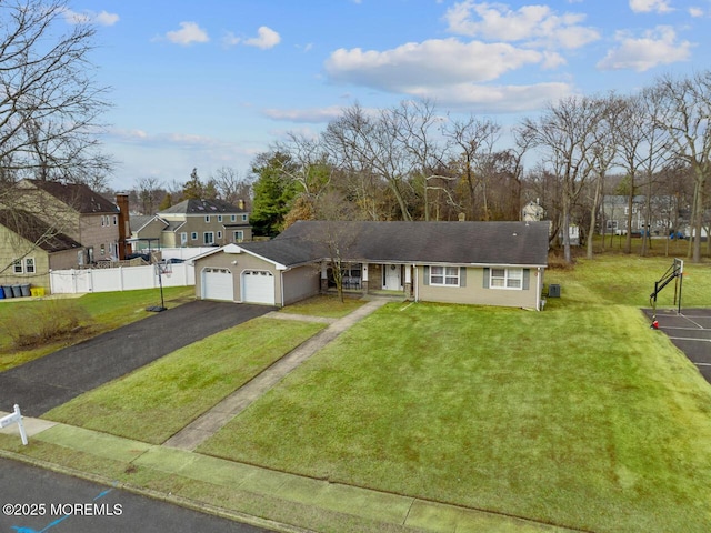 view of front of property with a front lawn, an attached garage, driveway, and fence