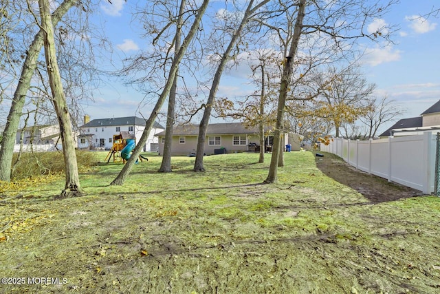 view of yard with fence and a playground