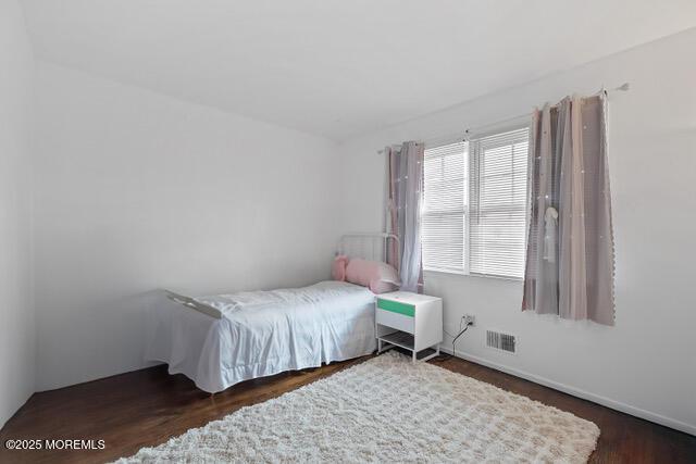 bedroom featuring wood finished floors and visible vents