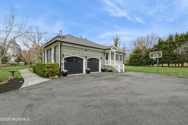 view of side of property with an attached garage, a shingled roof, driveway, and a lawn