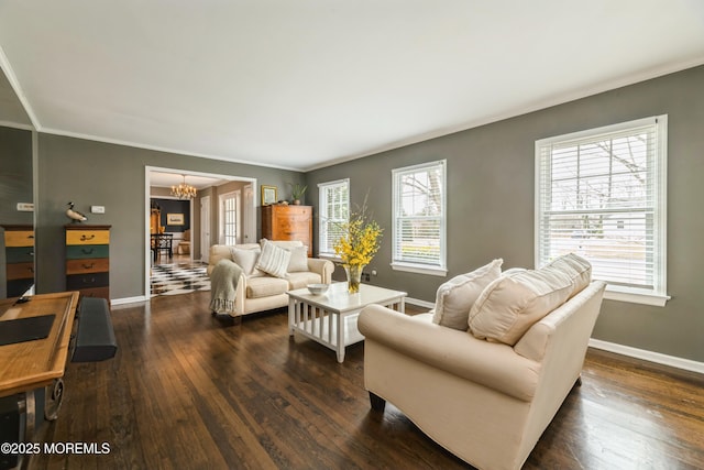 living area with dark wood-type flooring, a notable chandelier, and a healthy amount of sunlight