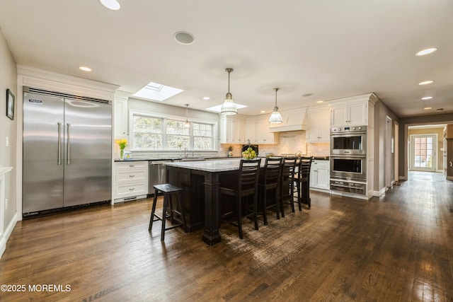 kitchen with a warming drawer, decorative backsplash, appliances with stainless steel finishes, and a wealth of natural light