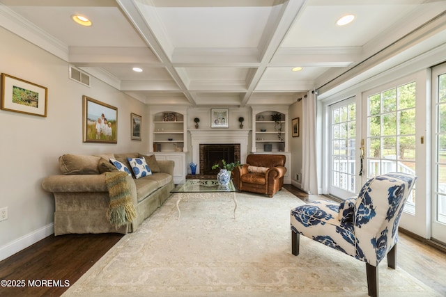 living room featuring wood finished floors, visible vents, coffered ceiling, baseboards, and beamed ceiling