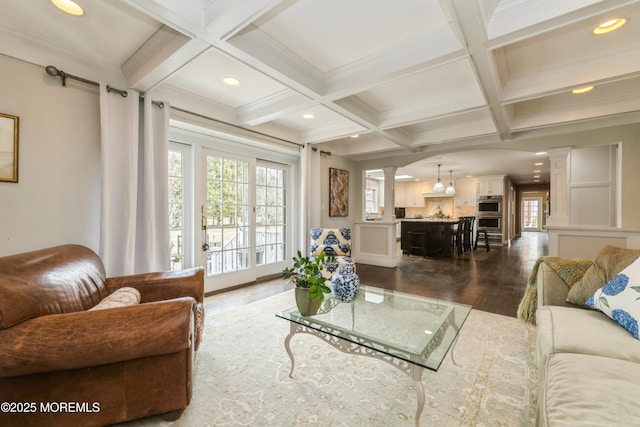 living area featuring beamed ceiling, coffered ceiling, dark wood-style floors, and ornate columns