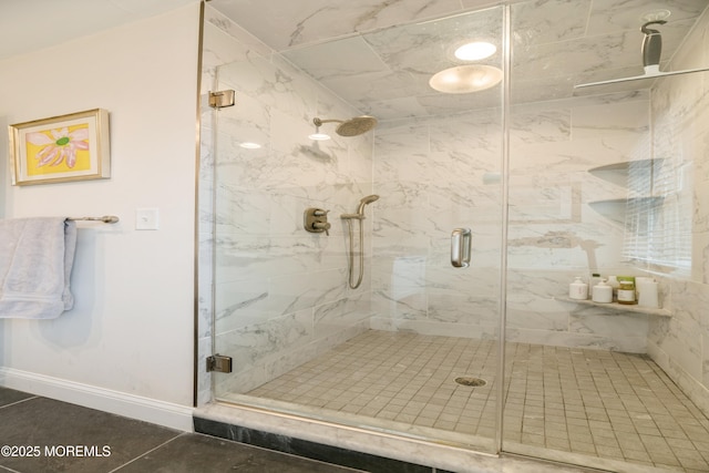 bathroom with a shower stall, baseboards, and tile patterned floors