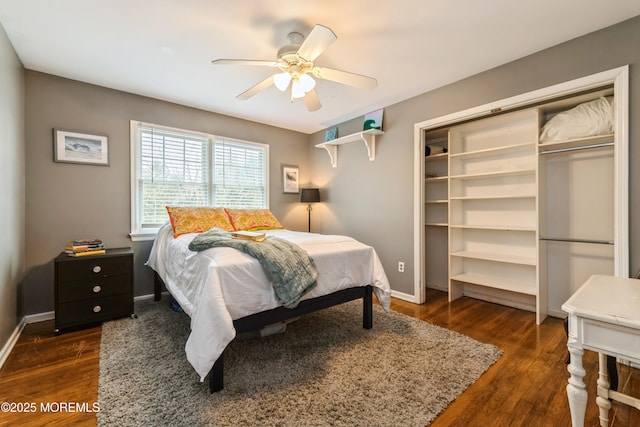 bedroom with dark wood finished floors, ceiling fan, a closet, and baseboards