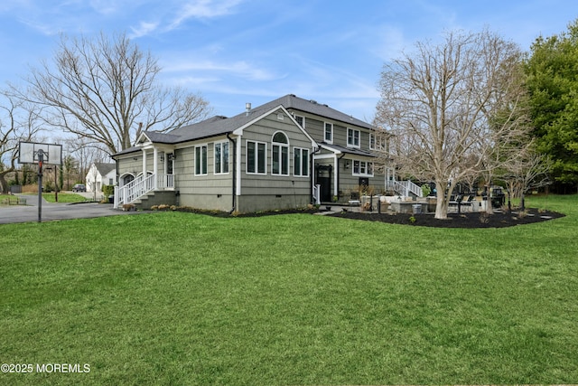 back of property featuring crawl space, a yard, a shingled roof, and aphalt driveway