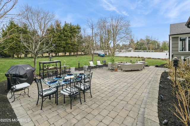 view of patio featuring outdoor dining space, area for grilling, fence, and an outdoor fire pit