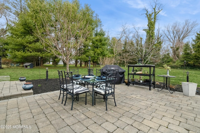 view of patio / terrace with grilling area, an outdoor structure, and outdoor dining space