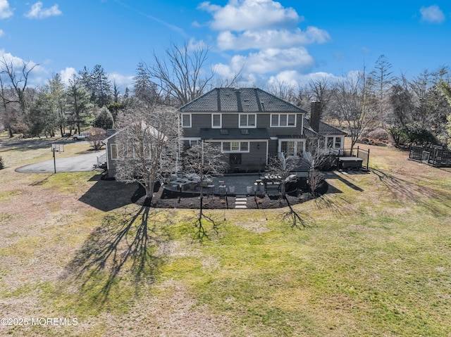 rear view of house featuring a lawn, a deck, and fence