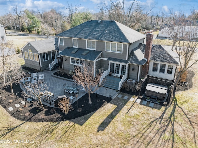 rear view of property with a deck, a lawn, a chimney, and a shingled roof