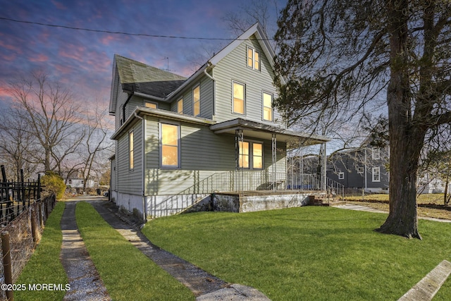 property exterior at dusk featuring covered porch and a lawn