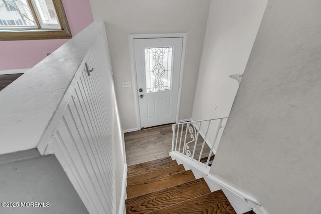 staircase with wood finished floors and baseboards