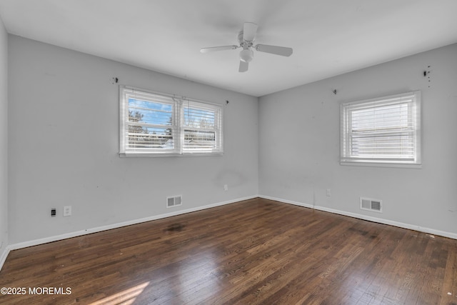 spare room featuring baseboards, visible vents, and hardwood / wood-style floors