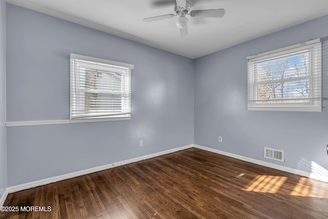 empty room with a ceiling fan, baseboards, visible vents, and wood finished floors