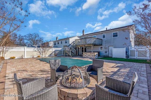 exterior space featuring an outdoor fire pit, a patio, a fenced backyard, stairway, and a deck