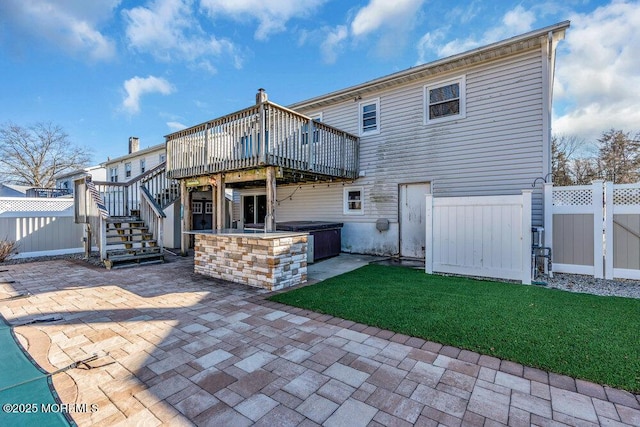 rear view of house with a patio, stairs, fence, a deck, and a yard