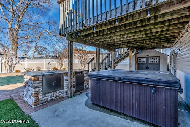 view of patio featuring stairway, fence, a hot tub, and area for grilling