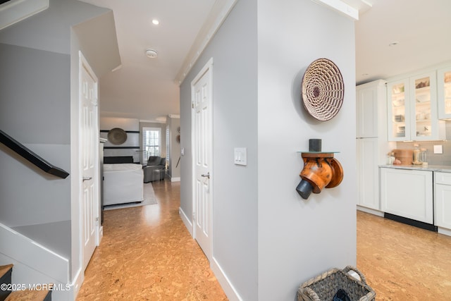 hall with recessed lighting, light floors, and baseboards