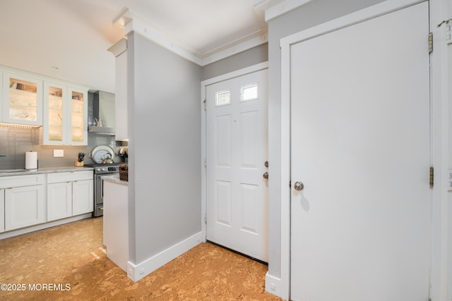 entryway with baseboards and ornamental molding