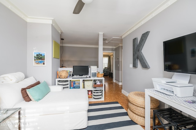 living room with baseboards, attic access, crown molding, and ceiling fan