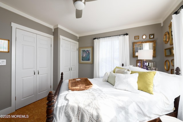 bedroom with two closets, crown molding, and a ceiling fan