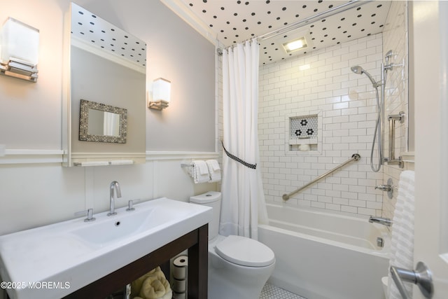 bathroom with wainscoting, vanity, toilet, and shower / tub combo