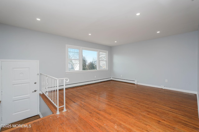 empty room with recessed lighting, baseboards, baseboard heating, and wood finished floors