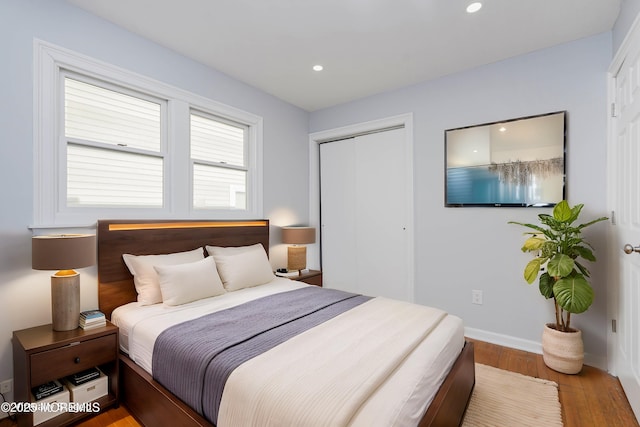 bedroom featuring light wood-style floors, baseboards, a closet, and recessed lighting