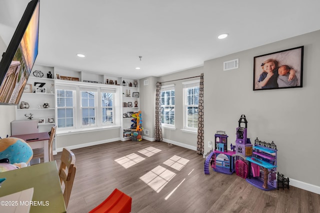 rec room with baseboards, visible vents, and wood finished floors