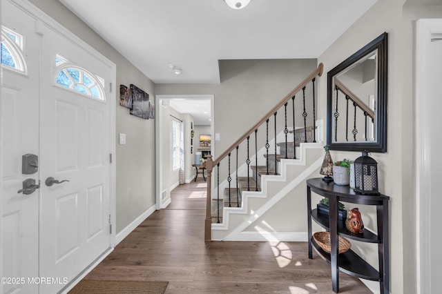 entrance foyer featuring stairs, baseboards, and wood finished floors