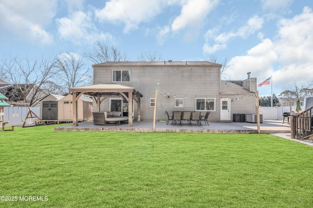 back of property featuring an outbuilding, a patio, a gazebo, a storage shed, and a fenced backyard