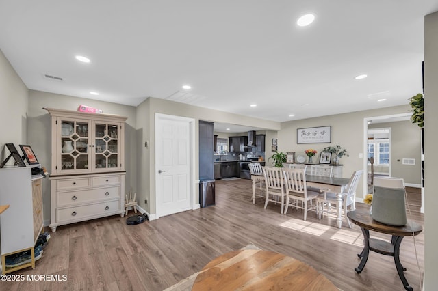 dining room featuring recessed lighting, baseboards, visible vents, and light wood finished floors