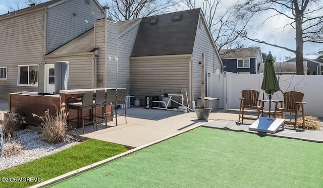 back of property with roof with shingles, a chimney, outdoor dry bar, a patio area, and fence