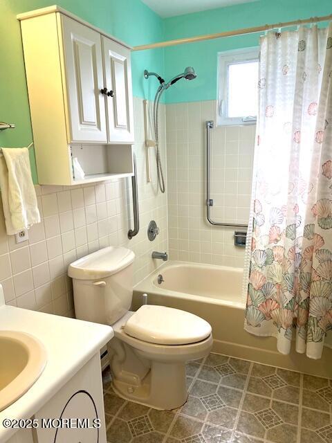 full bath with tile patterned flooring, toilet, vanity, tile walls, and shower / bathtub combination with curtain