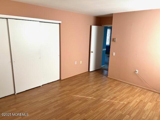 unfurnished bedroom featuring light wood-type flooring and a closet