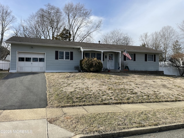 ranch-style home with an attached garage and aphalt driveway