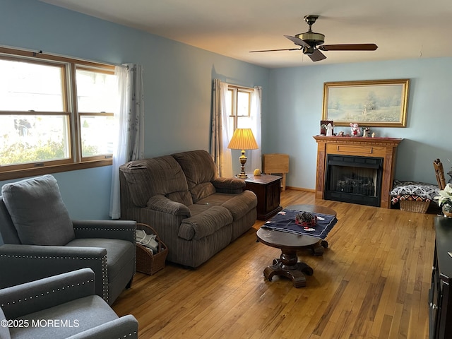 living room with a ceiling fan, a fireplace, and hardwood / wood-style floors