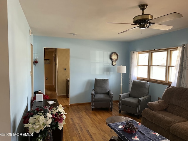 living room with baseboards, ceiling fan, and light wood finished floors