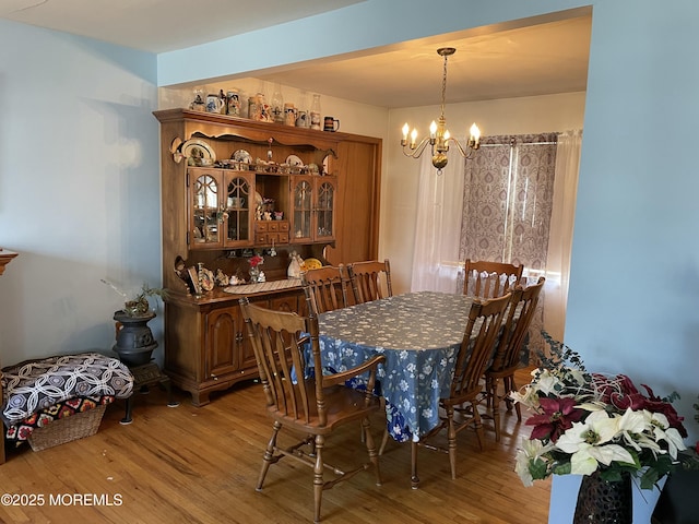 dining room with light wood finished floors and an inviting chandelier