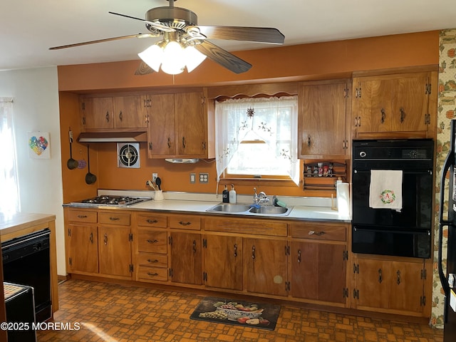 kitchen featuring black appliances, brown cabinets, a sink, and a warming drawer