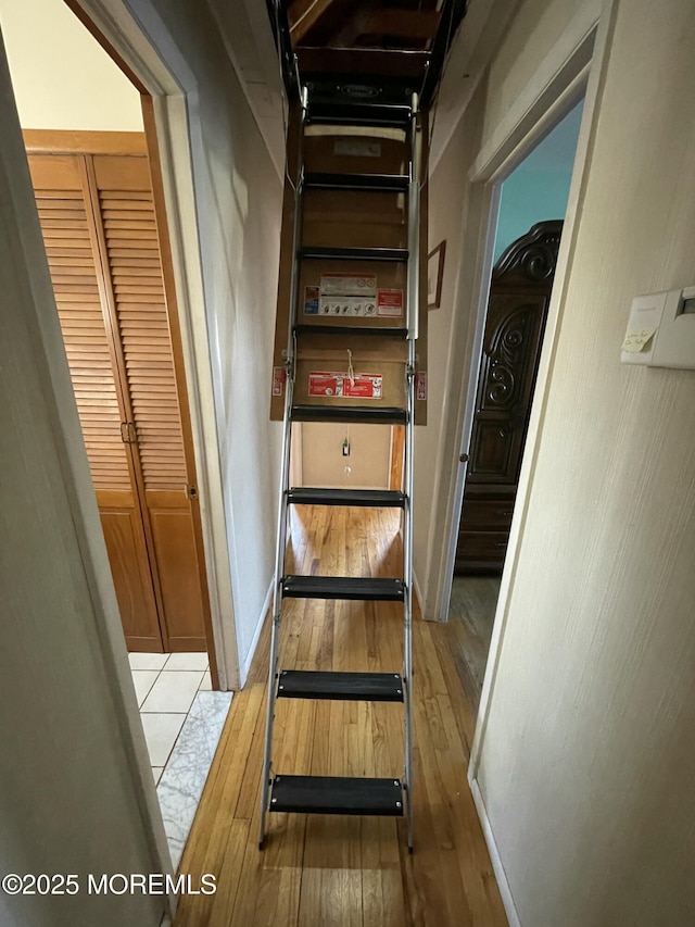 staircase with wood-type flooring and baseboards