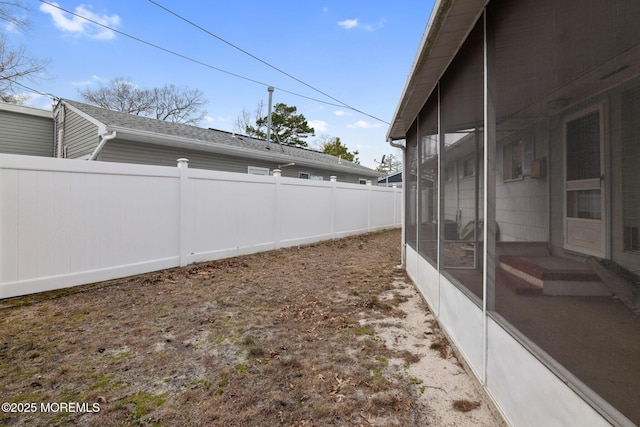 view of yard with a sunroom and fence