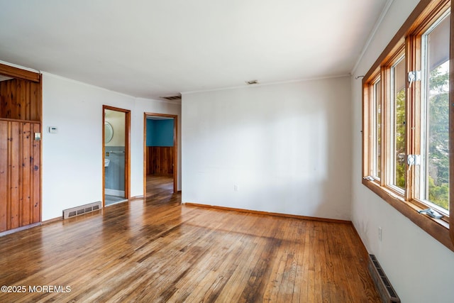 625 Twin River Dr, Forked River, NJ 08731 - empty room with plenty of natural light, a baseboard heating unit, hardwood / wood-style flooring, baseboards, and crown molding
