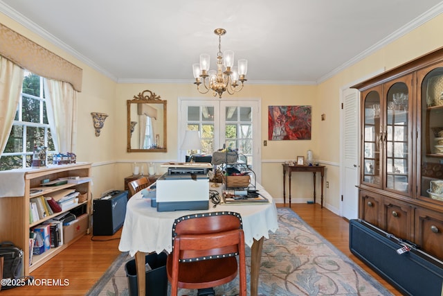 dining room featuring an inviting chandelier, ornamental molding, and wood finished floors