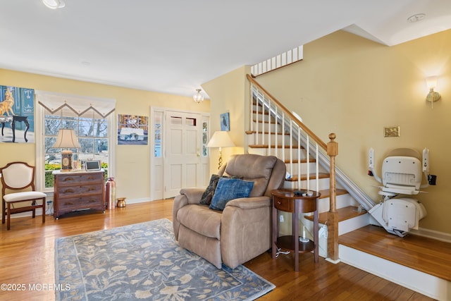 interior space featuring hardwood / wood-style floors, stairway, and baseboards