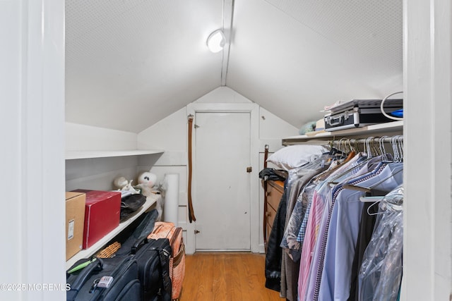 spacious closet with vaulted ceiling and wood finished floors