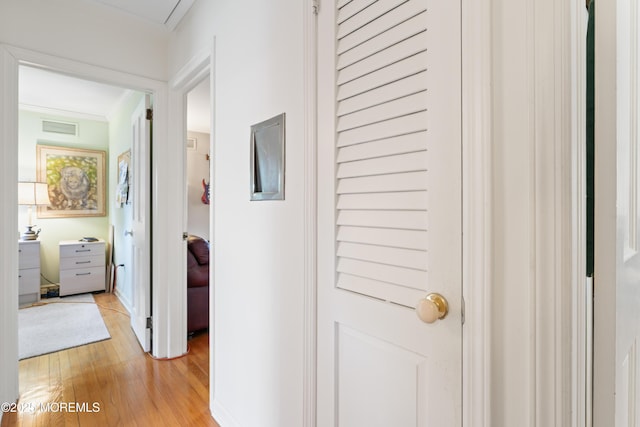 corridor featuring light wood-style floors and visible vents