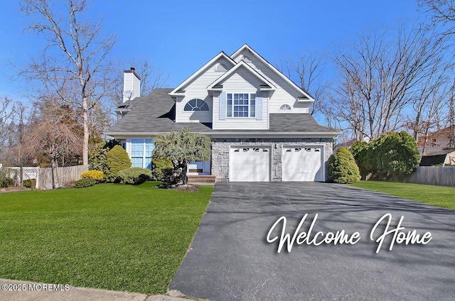 traditional-style home featuring an attached garage, aphalt driveway, a front yard, and fence