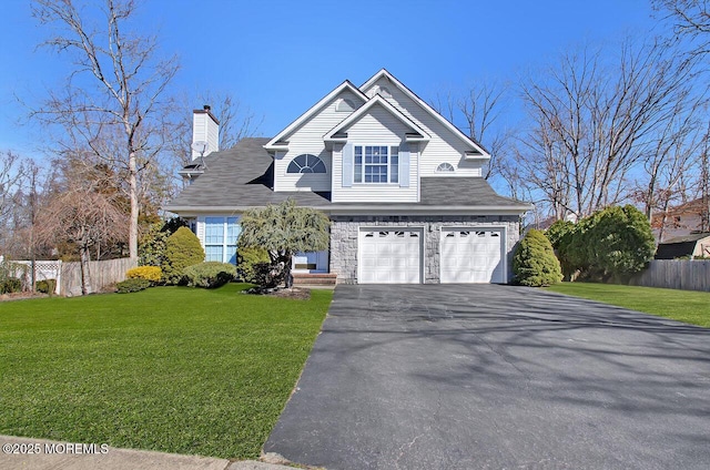 view of front of house with an attached garage, fence, driveway, a front lawn, and a chimney